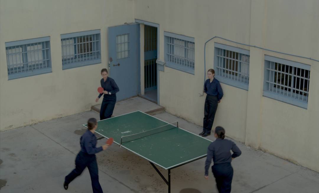 Still from the film Music by Angela Schanelec: prisoners play ping pong in the prison yard