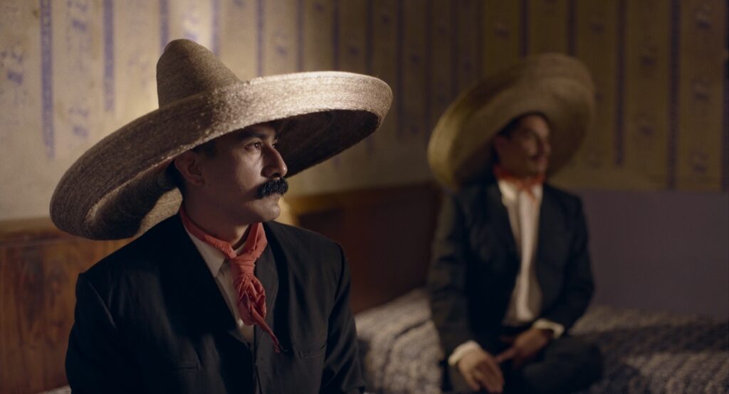 Still from the film Pornomelancholia by Manuel Abramovich: Lalo Santos as Emiliano Zapata sitting on the bed