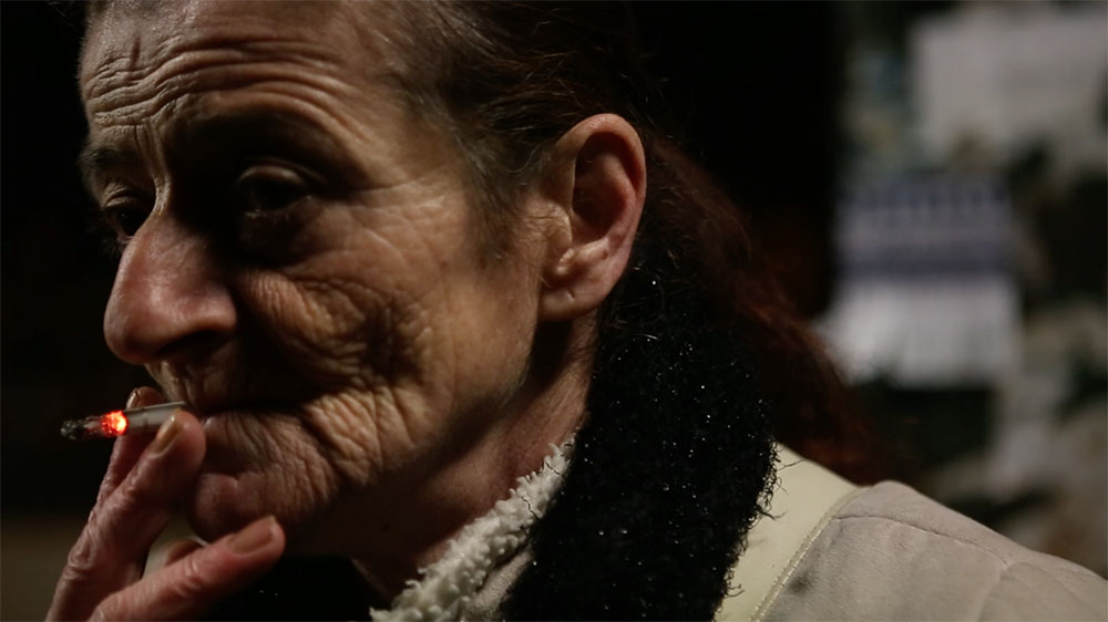 Záber z filmu A Woman Captured: staršia žena fajčí cigaretu